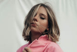 Woman with shoulder length blonde hair and pink shirt