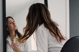 Woman looking at herself in the mirror